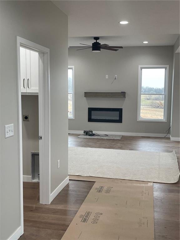 unfurnished living room featuring dark hardwood / wood-style floors and ceiling fan