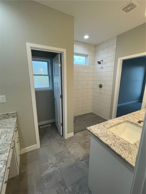 bathroom featuring vanity and a tile shower