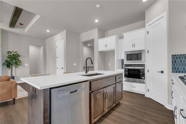 kitchen featuring dark hardwood / wood-style floors, a kitchen island with sink, stainless steel appliances, sink, and white cabinetry