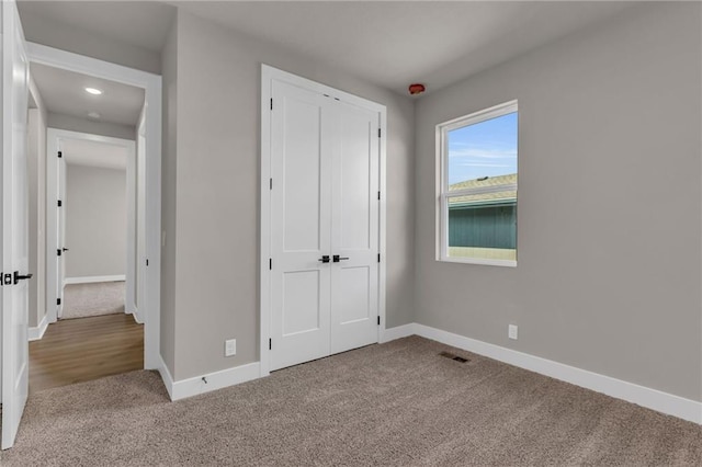 unfurnished bedroom featuring a closet and light carpet