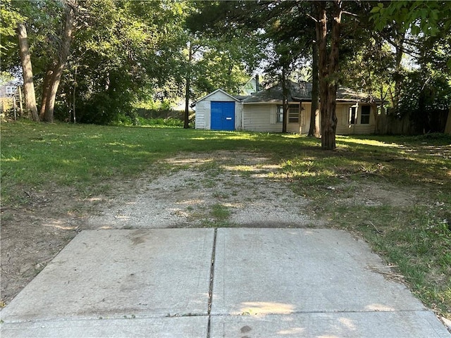 view of yard featuring a garage and an outbuilding