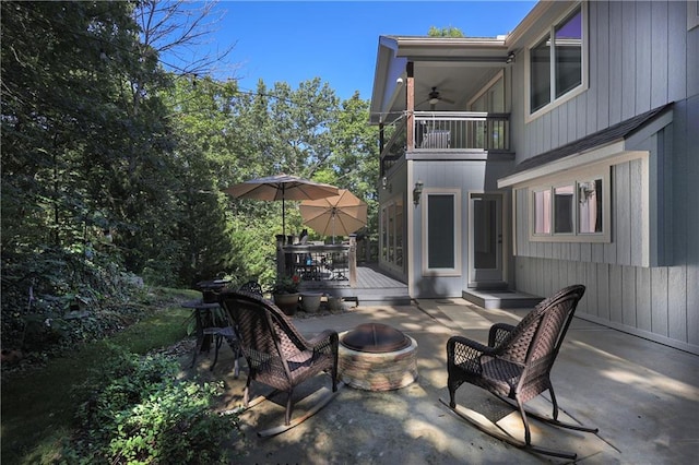 view of patio / terrace with a balcony, a fire pit, and a wooden deck