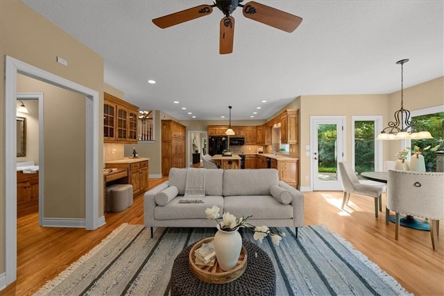 living room with ceiling fan and light hardwood / wood-style floors