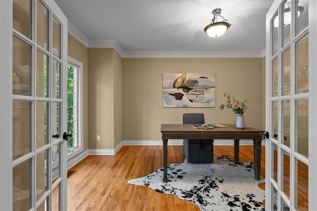 office area with light wood-type flooring, crown molding, and french doors