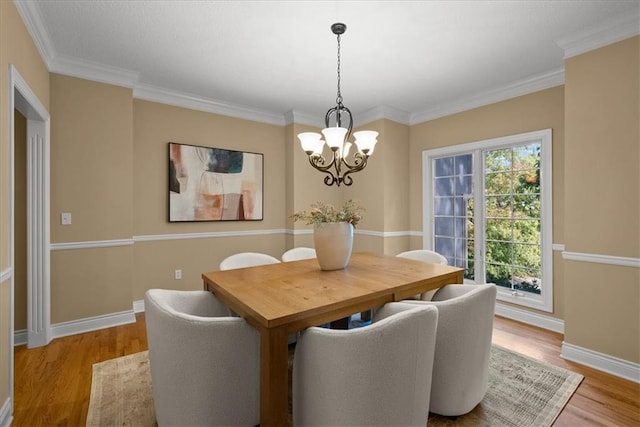 dining space with a chandelier, light hardwood / wood-style floors, and crown molding