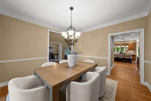 dining room featuring a chandelier, crown molding, and light hardwood / wood-style floors