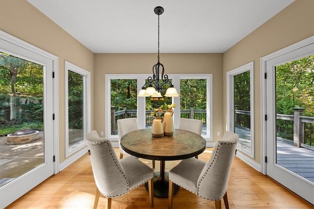 sunroom featuring plenty of natural light and a notable chandelier