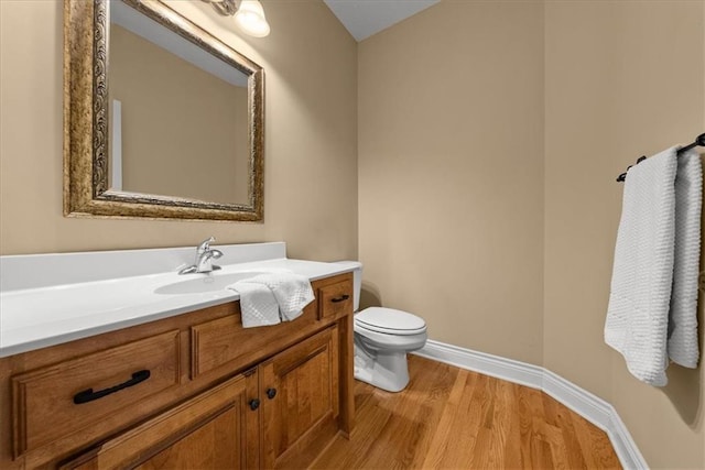 bathroom featuring toilet, vanity, and hardwood / wood-style flooring