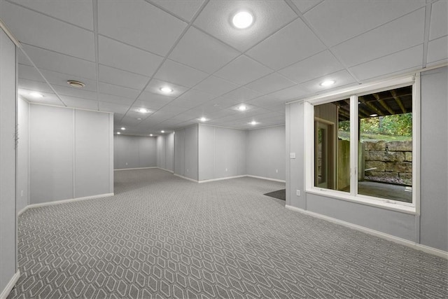 basement featuring a paneled ceiling and carpet floors