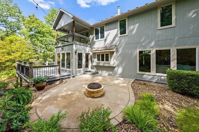 rear view of house featuring a patio, a balcony, a fire pit, and a wooden deck