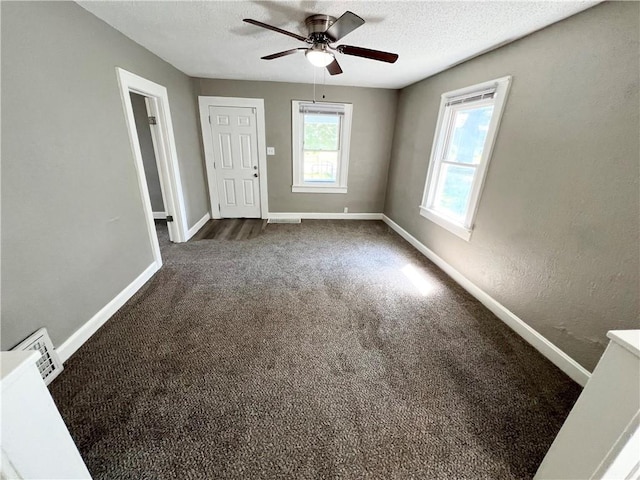 carpeted spare room with a textured ceiling and ceiling fan