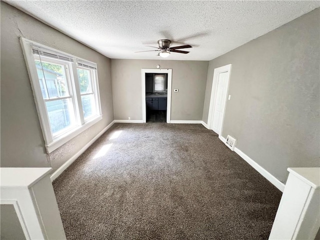 carpeted spare room with a textured ceiling and ceiling fan