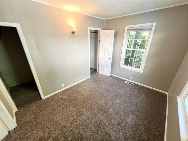 spare room featuring crown molding and carpet floors