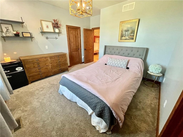 carpeted bedroom featuring an inviting chandelier