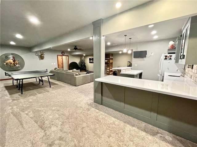 interior space featuring pendant lighting, white refrigerator, sink, kitchen peninsula, and light colored carpet