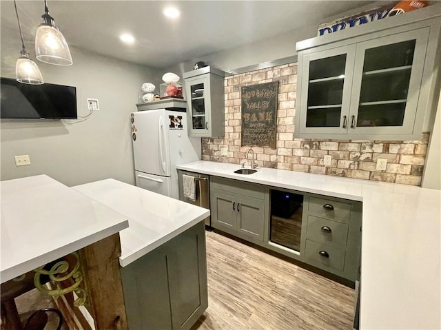 kitchen featuring pendant lighting, wine cooler, white refrigerator, light hardwood / wood-style floors, and sink