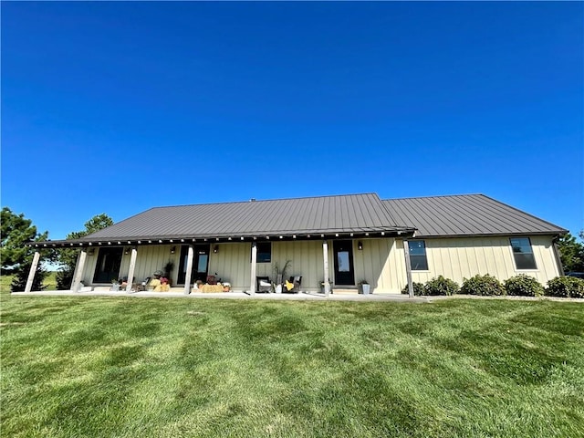 rear view of property featuring a lawn