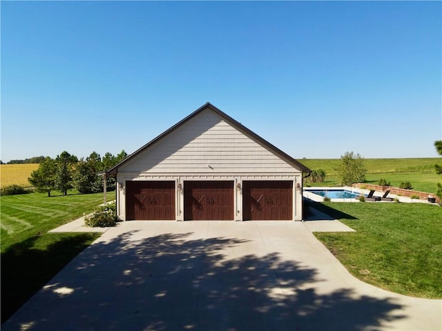 garage with a lawn and a rural view