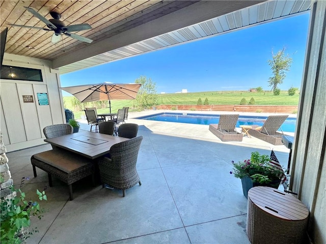 view of patio with ceiling fan and a swimming pool with hot tub