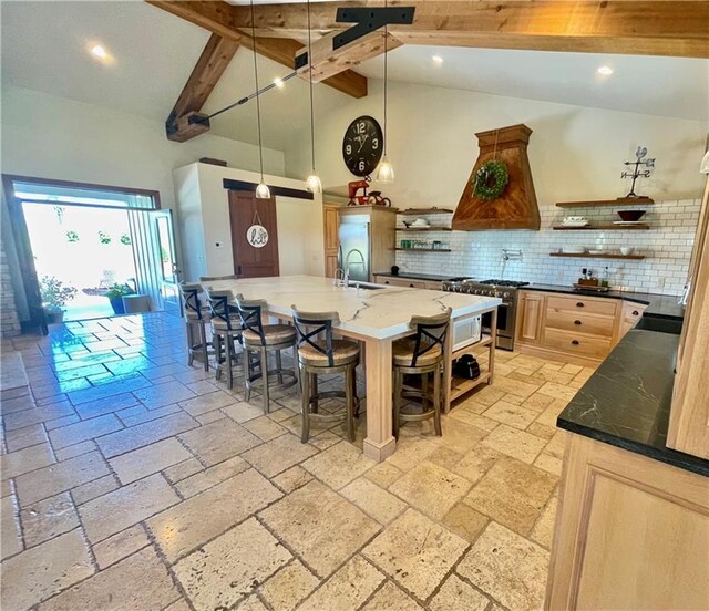 kitchen with sink, beam ceiling, high vaulted ceiling, a kitchen breakfast bar, and light brown cabinetry