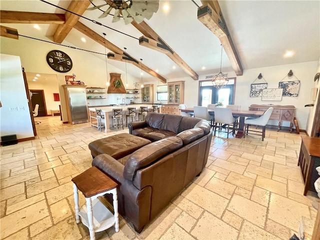 living room with ceiling fan with notable chandelier, beamed ceiling, and high vaulted ceiling