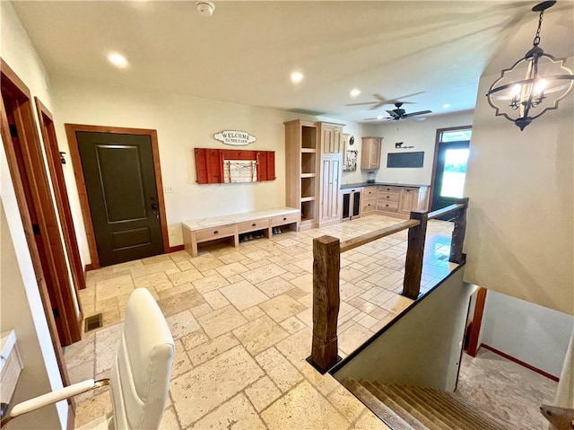 dining space featuring ceiling fan with notable chandelier