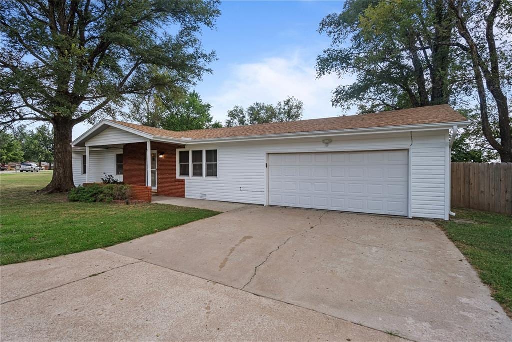 ranch-style home with a garage and a front lawn