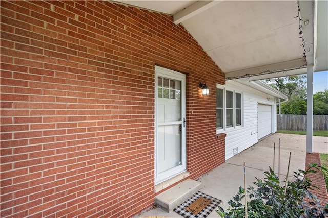 doorway to property with a garage and a patio