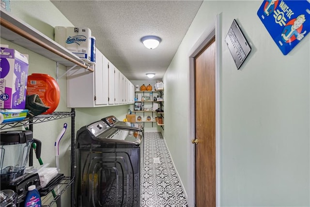 clothes washing area featuring a textured ceiling, cabinets, washer and dryer, and tile patterned floors