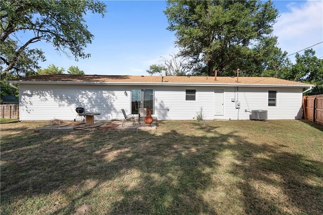 rear view of house with a yard and cooling unit