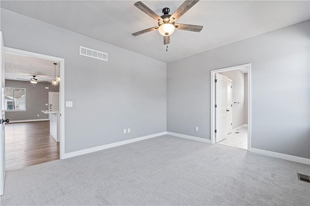 spare room with light carpet and ceiling fan