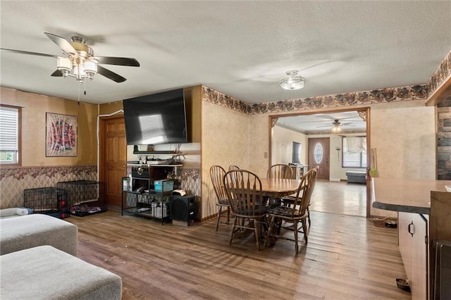 dining room with a textured ceiling, hardwood / wood-style flooring, and ceiling fan