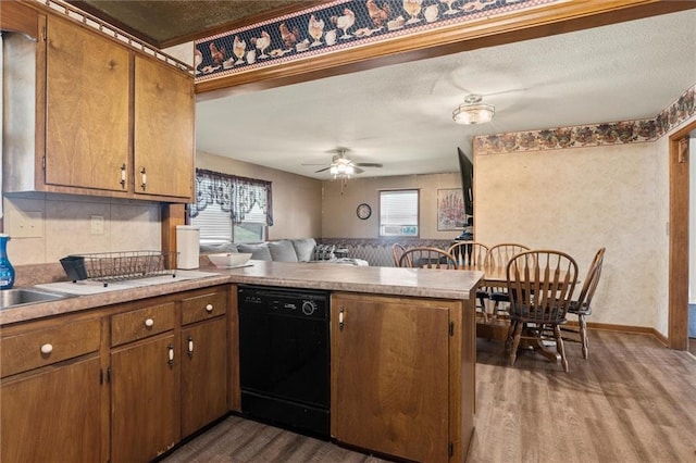 kitchen with plenty of natural light, black dishwasher, kitchen peninsula, and ceiling fan