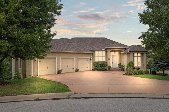 prairie-style house featuring a garage and a yard