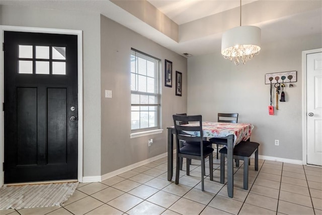 dining space featuring light tile patterned floors, baseboards, and a chandelier