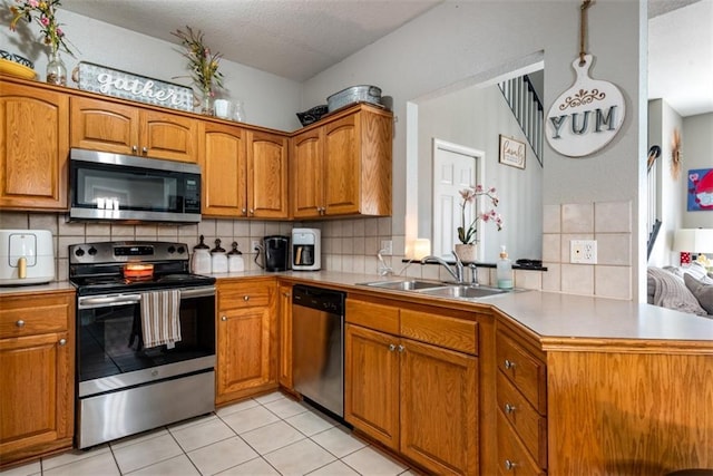 kitchen with brown cabinetry, appliances with stainless steel finishes, and light countertops