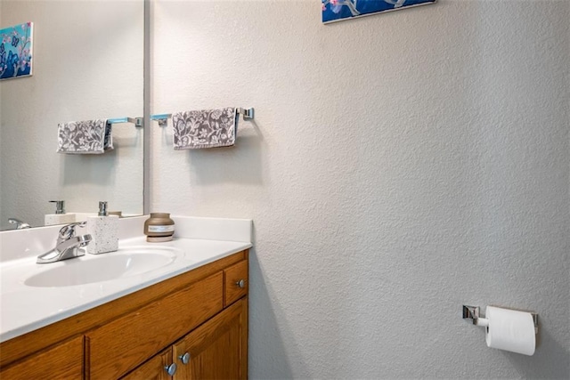 bathroom with vanity and a textured wall