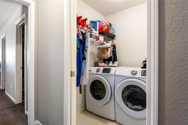 clothes washing area featuring washing machine and dryer and a textured wall