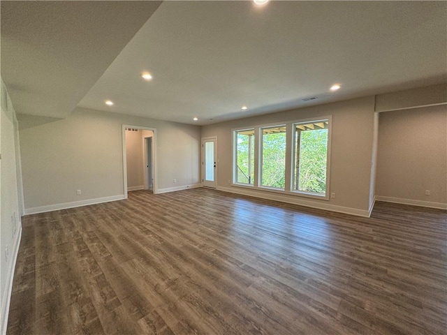 unfurnished living room featuring recessed lighting, dark wood finished floors, and baseboards