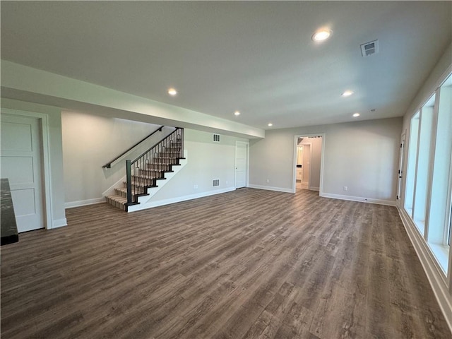 unfurnished living room with recessed lighting, dark wood-style flooring, stairway, visible vents, and baseboards