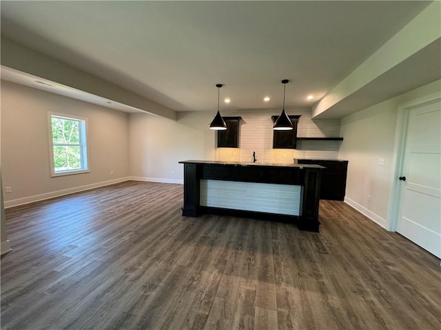 kitchen featuring baseboards, dark wood-style flooring, open floor plan, recessed lighting, and an island with sink