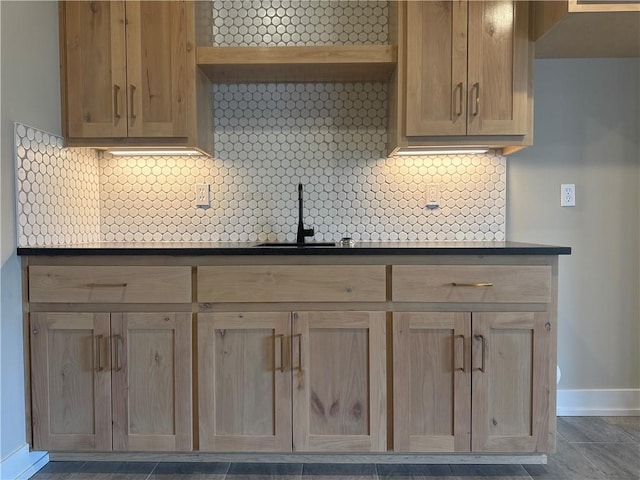 kitchen featuring light brown cabinetry, sink, and backsplash