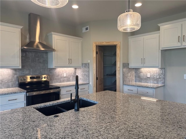 kitchen with stainless steel electric range, white cabinetry, hanging light fixtures, and wall chimney exhaust hood