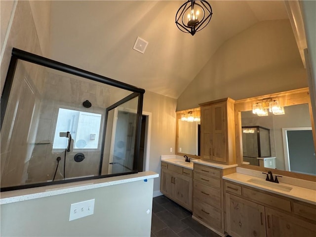 bathroom with vaulted ceiling, a shower with shower door, a chandelier, vanity, and tile patterned floors