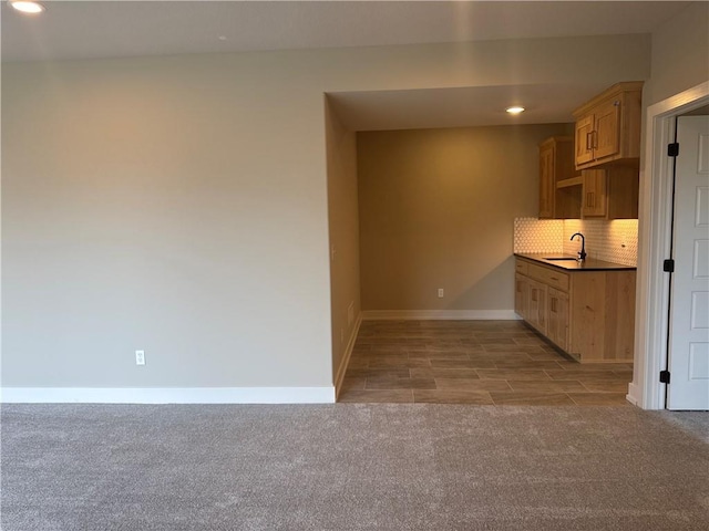 kitchen with sink, light carpet, light brown cabinetry, and decorative backsplash