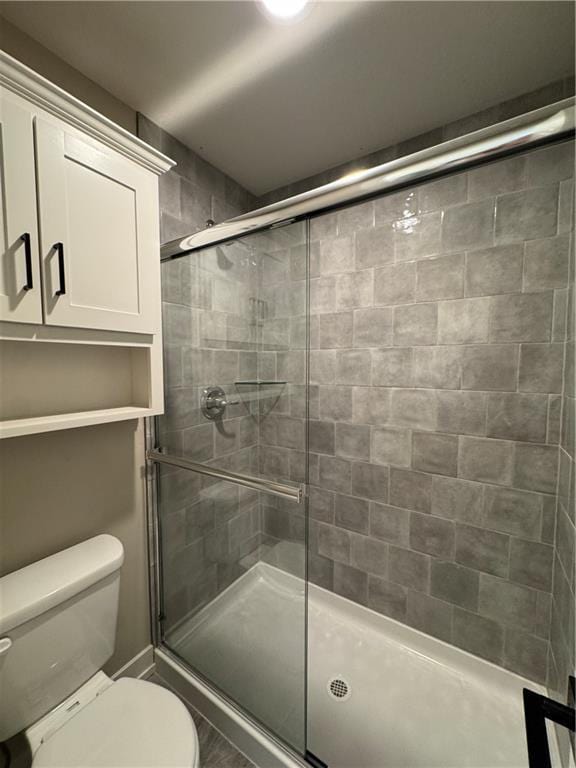 bathroom featuring an enclosed shower and toilet