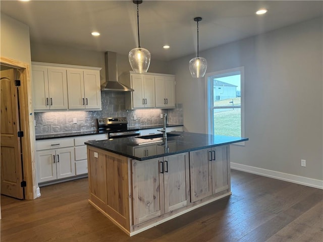 kitchen with stainless steel electric range oven, a kitchen island with sink, white cabinets, and wall chimney exhaust hood