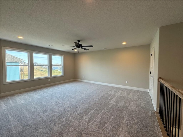 carpeted spare room with ceiling fan and a textured ceiling