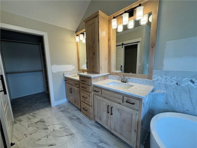 bathroom featuring lofted ceiling, vanity, and a bathtub