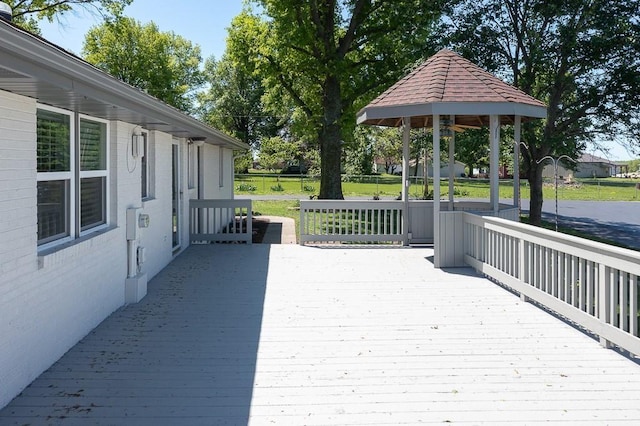 wooden deck featuring a yard and a gazebo